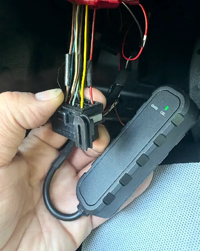 Install Leaders technician verifying a GPS device is reporting — green GPS and cellular status lights on before the install is finished